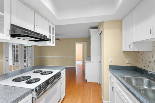 a view of empty room with wooden floor and ceiling fan