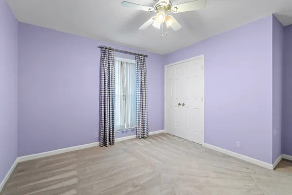 an empty room with a window and a ceiling fan