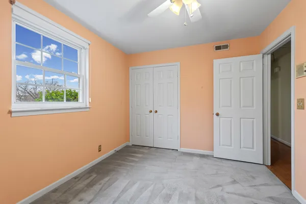 a bathroom with a granite countertop sink a mirror and a toilet
