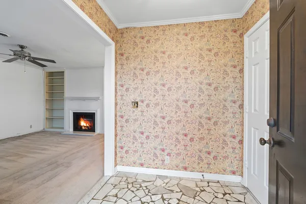 a view of an empty room with a fireplace and a window