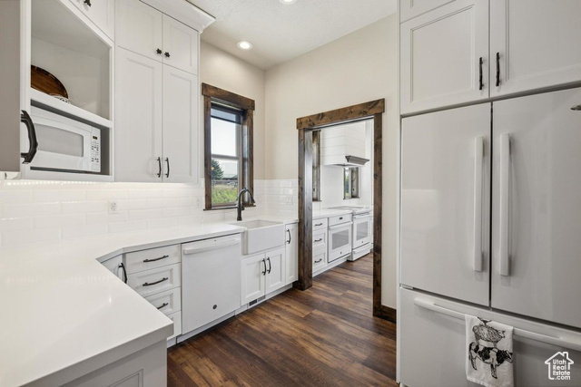 6117 North Rocky Ridge Road Peoa, UT 84061 - Photo 43 of 83 Kitchen featuring sink, white appliances, white cabinetry, tasteful backsplash, and dark hardwood / wood-style flooring