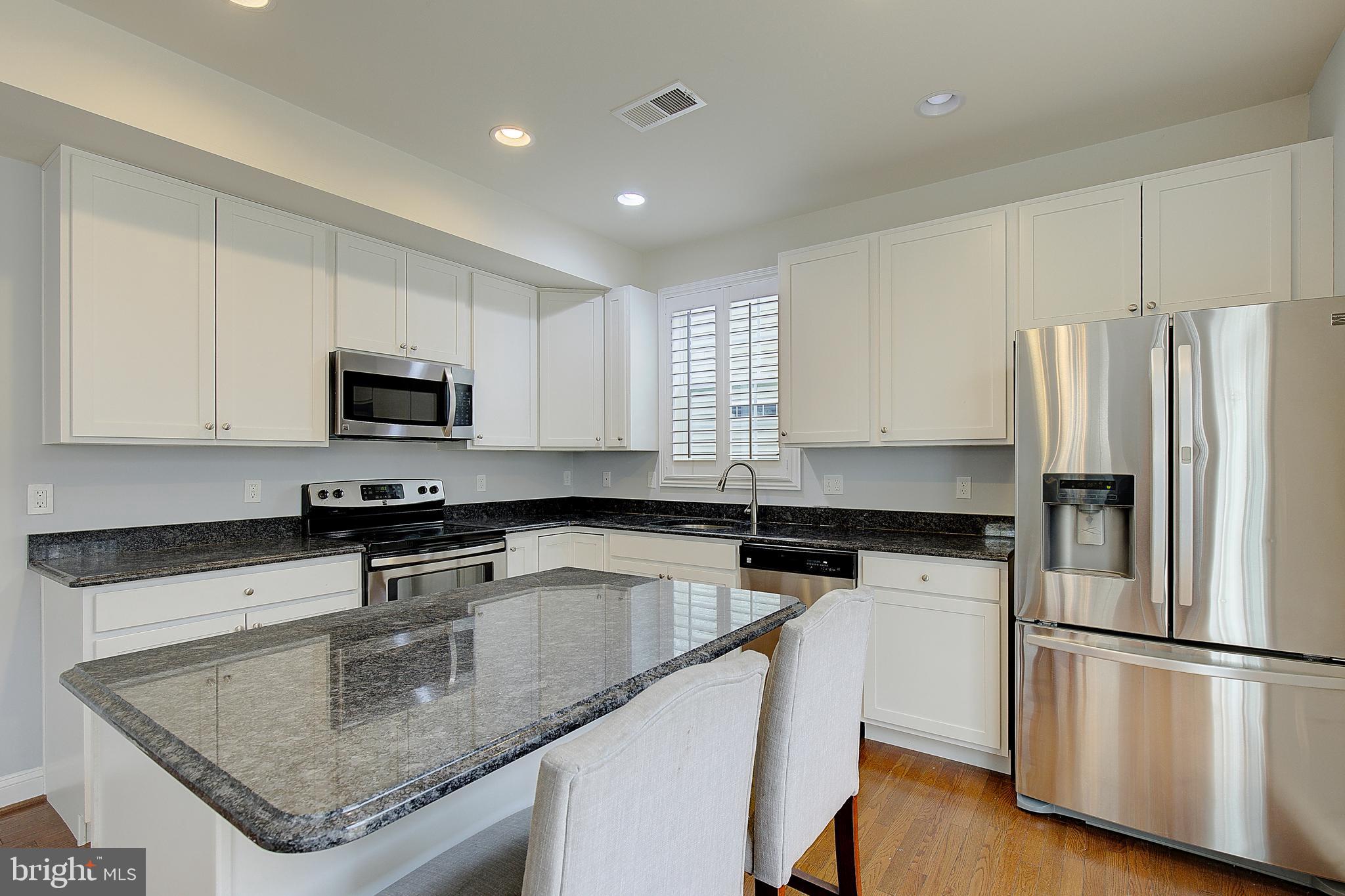 5952 Tyler Road Deale, MD 20751 - Photo 12 of 33 a kitchen with granite countertop a refrigerator a sink a stove a microwave and island