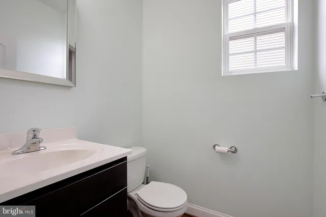 a bathroom with a sink a toilet and a window