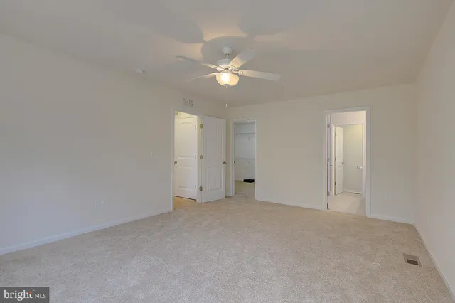 a view of an empty room with a ceiling fan