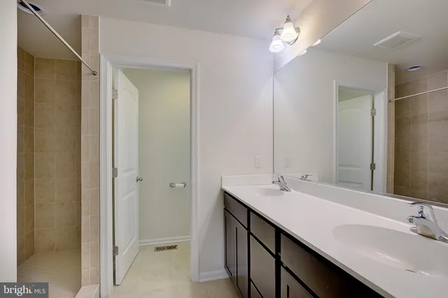 a bathroom with a double vanity sink and a mirror