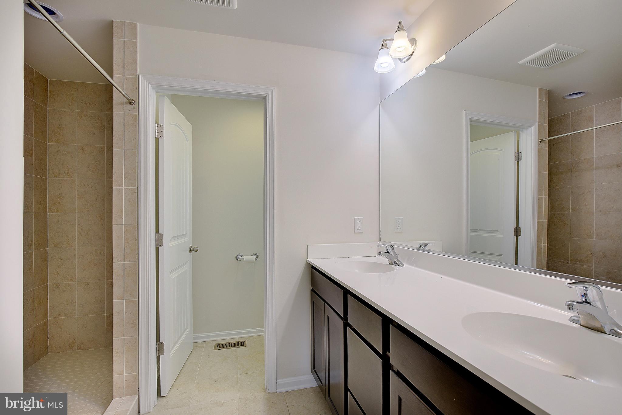 5952 Tyler Road Deale, MD 20751 - Photo 24 of 33 a bathroom with a double vanity sink and a mirror