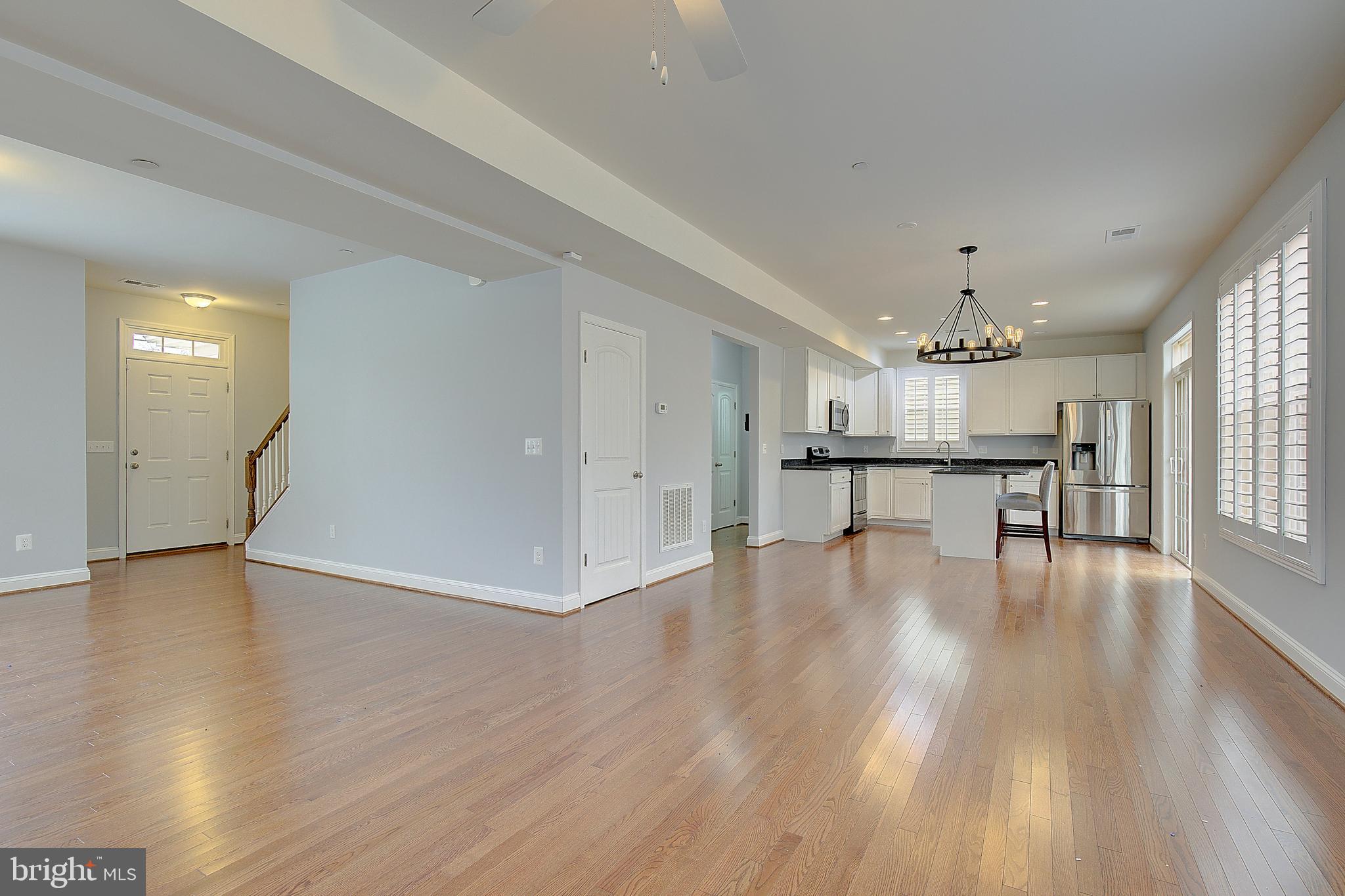 5952 Tyler Road Deale, MD 20751 - Photo 5 of 33 a view of an empty room with wooden floor and a kitchen