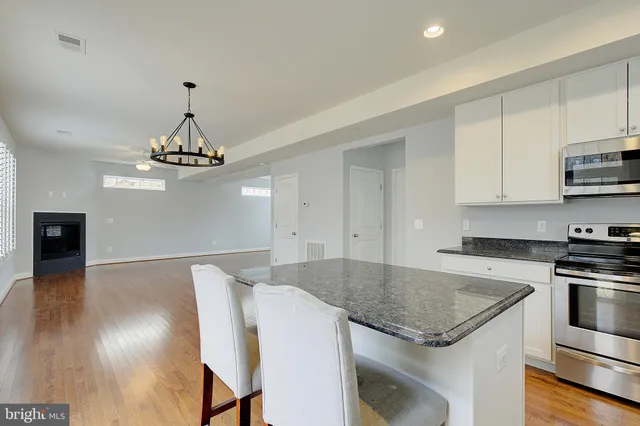a kitchen with stainless steel appliances granite countertop a sink and a stove