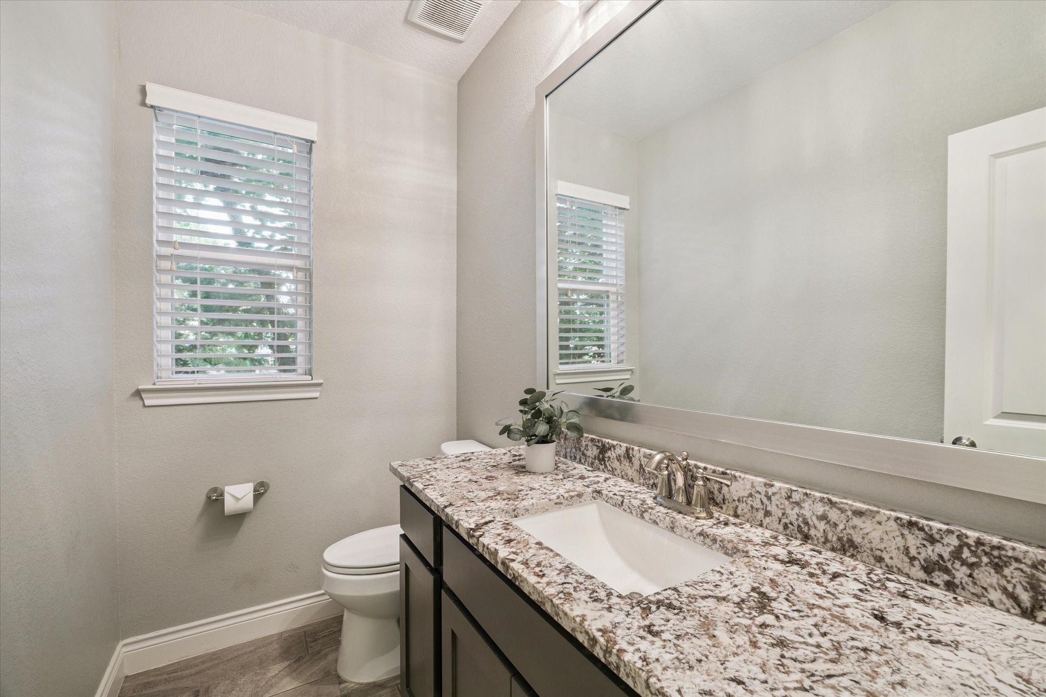 207 West 6th Street Kemah, TX 77565 - Photo 14 of 41 a bathroom with a granite countertop sink a toilet and a window