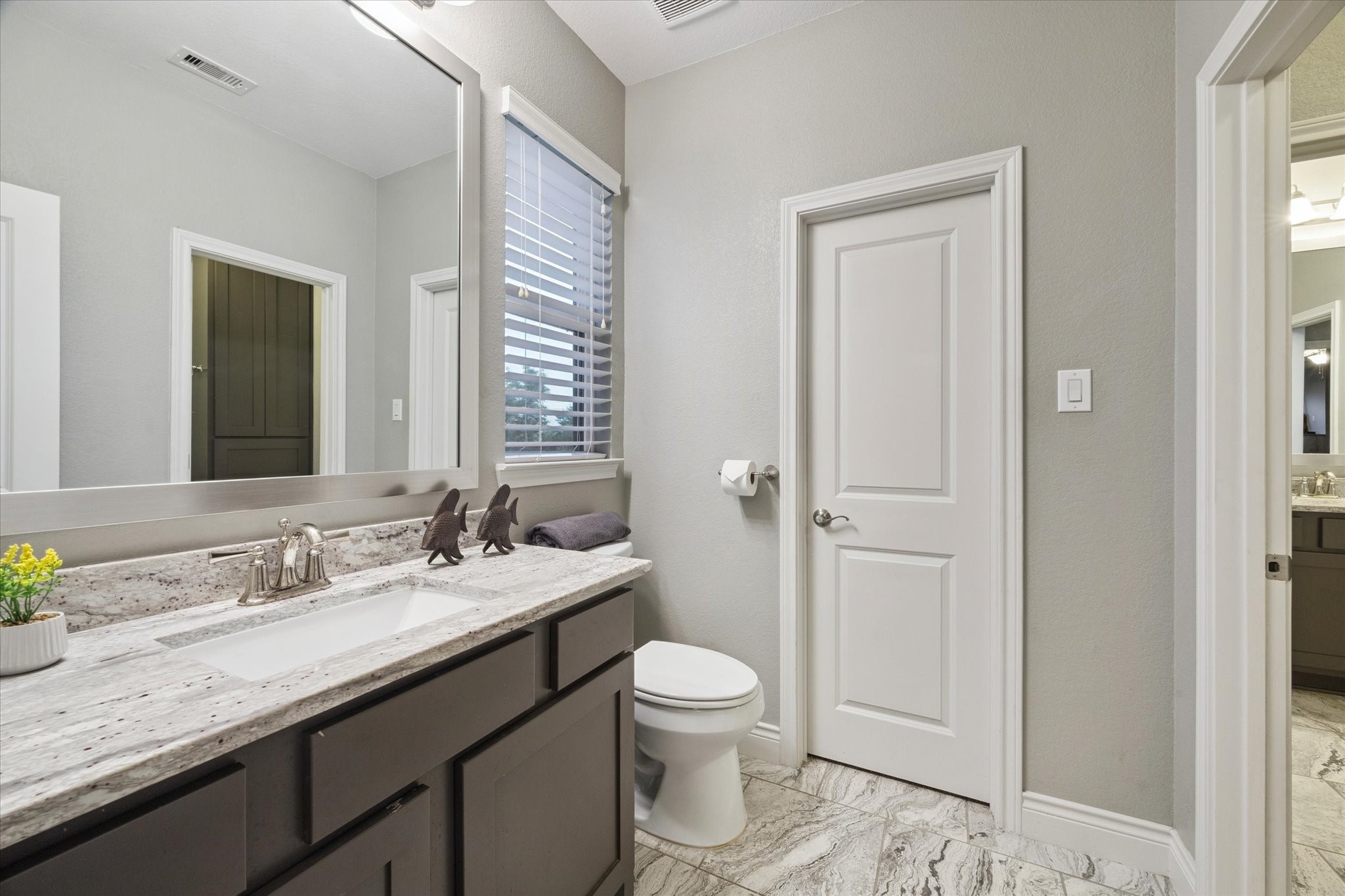 207 West 6th Street Kemah, TX 77565 - Photo 27 of 41 a bathroom with a granite countertop sink a toilet and a mirror