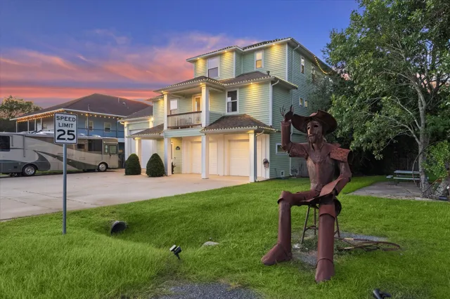 a front view of a house with a yard and a tree