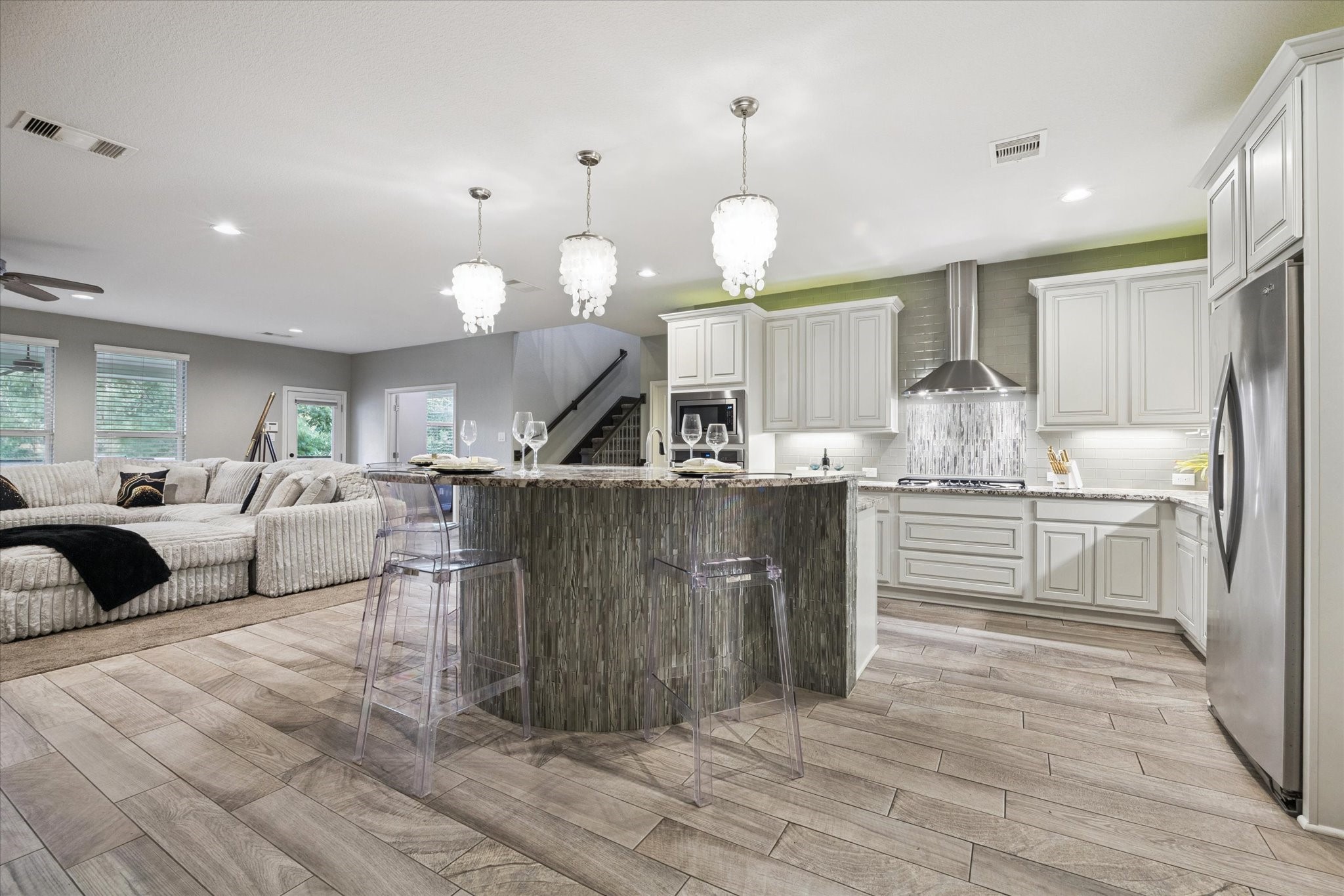 207 West 6th Street Kemah, TX 77565 - Photo 6 of 41 a kitchen with stainless steel appliances kitchen island granite countertop a stove a sink a refrigerator and white cabinets with wooden floor