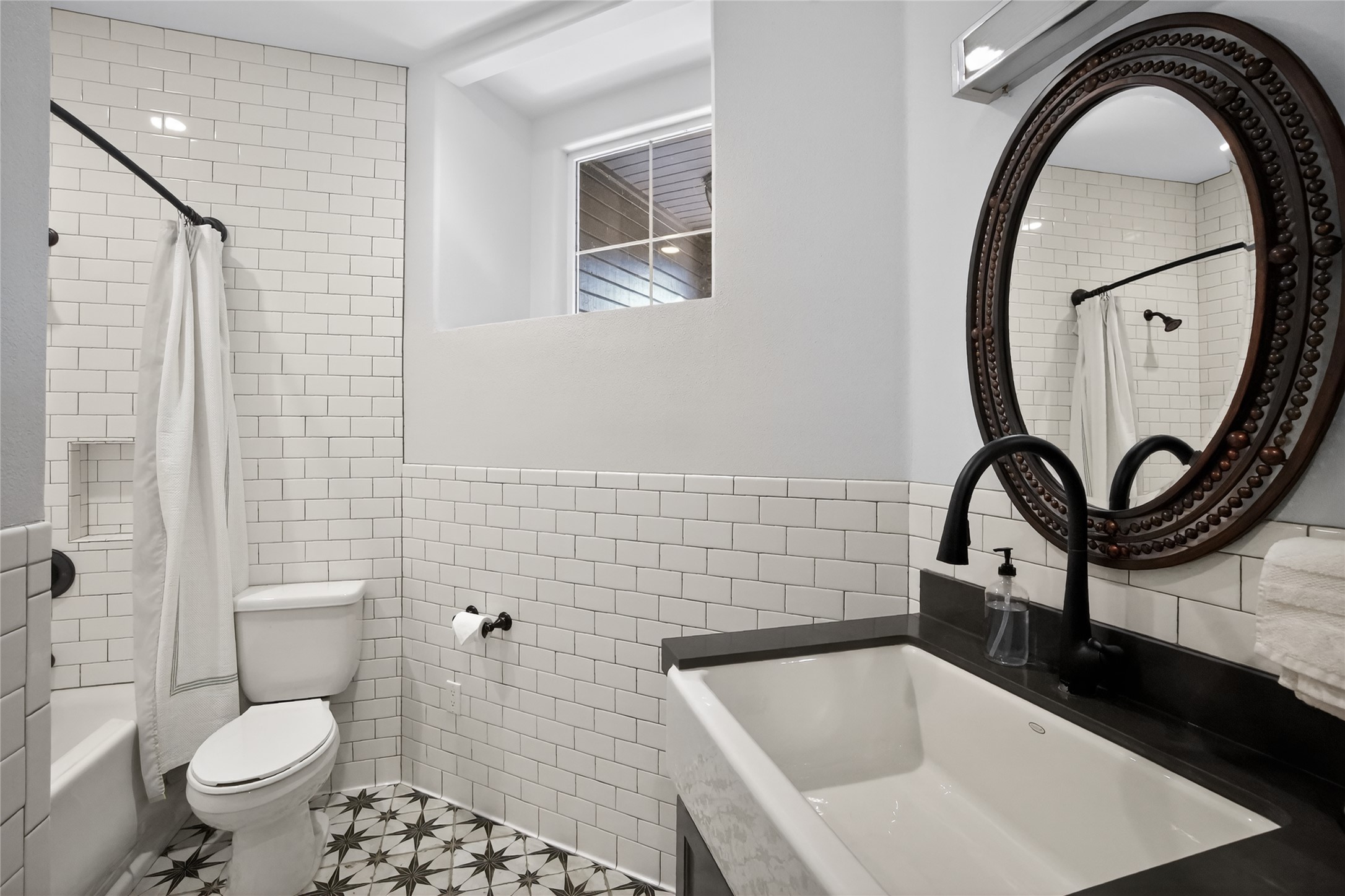 3627 Stoneridge Road Austin, TX 78746 - Photo 19 of 40 Bathroom with tile walls, vanity, shower / bathtub combination with curtain, a wainscoted wall, and light tile patterned floors