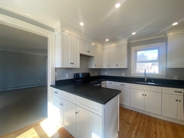 33 Ash Street Spencer, MA 01562 - Photo 19 of 37 a kitchen with granite countertop a sink a stove and cabinets
