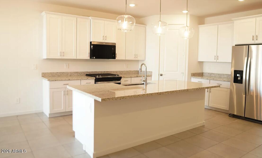 2426 Grenache Road San Tan Valley, AZ 85143 - Photo 3 of 29 a kitchen with stainless steel appliances a microwave a sink and a refrigerator