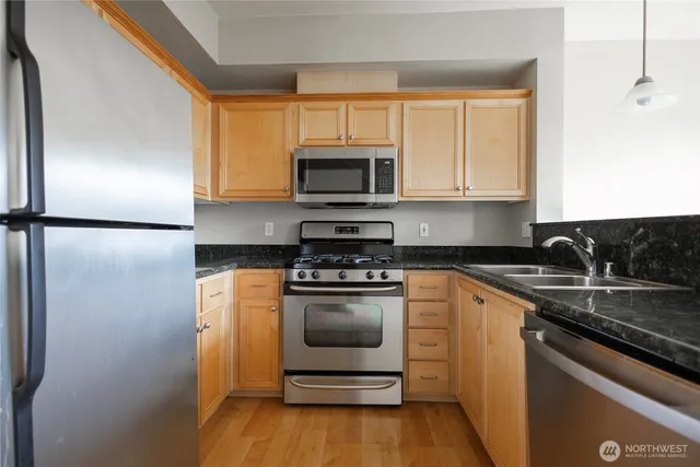 a kitchen with stainless steel appliances granite countertop a stove a refrigerator and a microwave