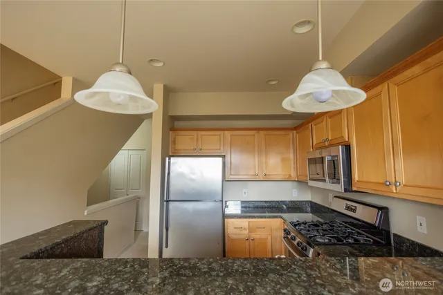 a kitchen with stainless steel appliances granite countertop a refrigerator and a stove