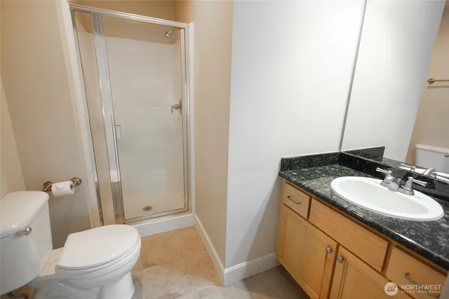 a bathroom with a granite countertop sink toilet and shower