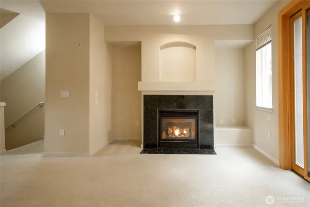a view of an empty room with a fireplace and a window