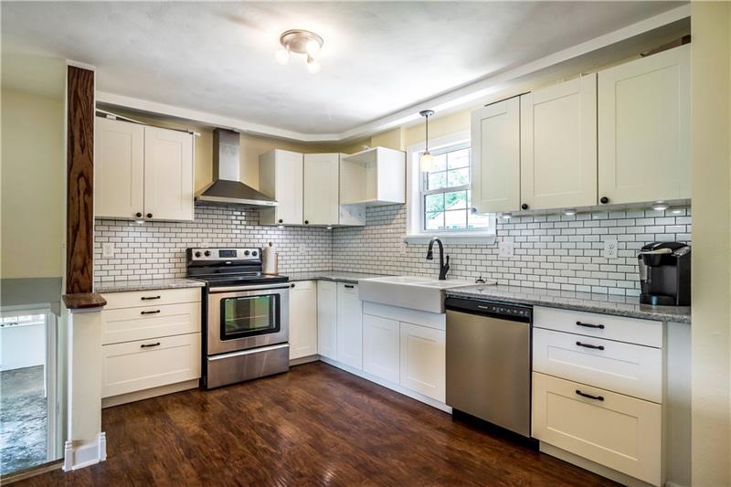 581 Arden Road Washington, PA 15301 - Photo 6 of 25 The completely updated kitchen has this rich wood flooring, wood beam detail, white subway tile and soft-close cabinetry . . .