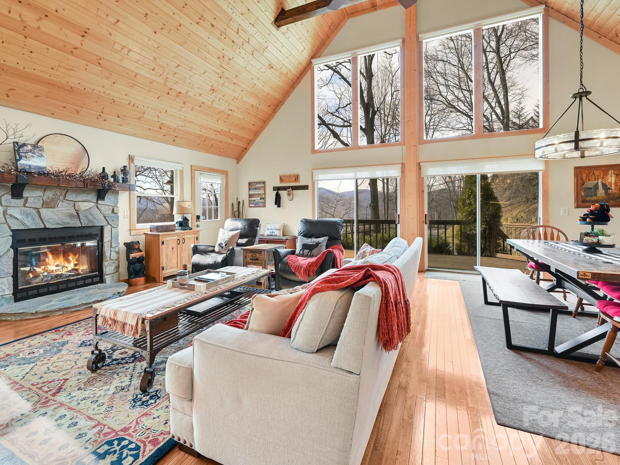 1954 Utah Mountain Road Waynesville, NC 28785 - Photo 12 of 36 a living room with furniture a fireplace and a floor to ceiling window