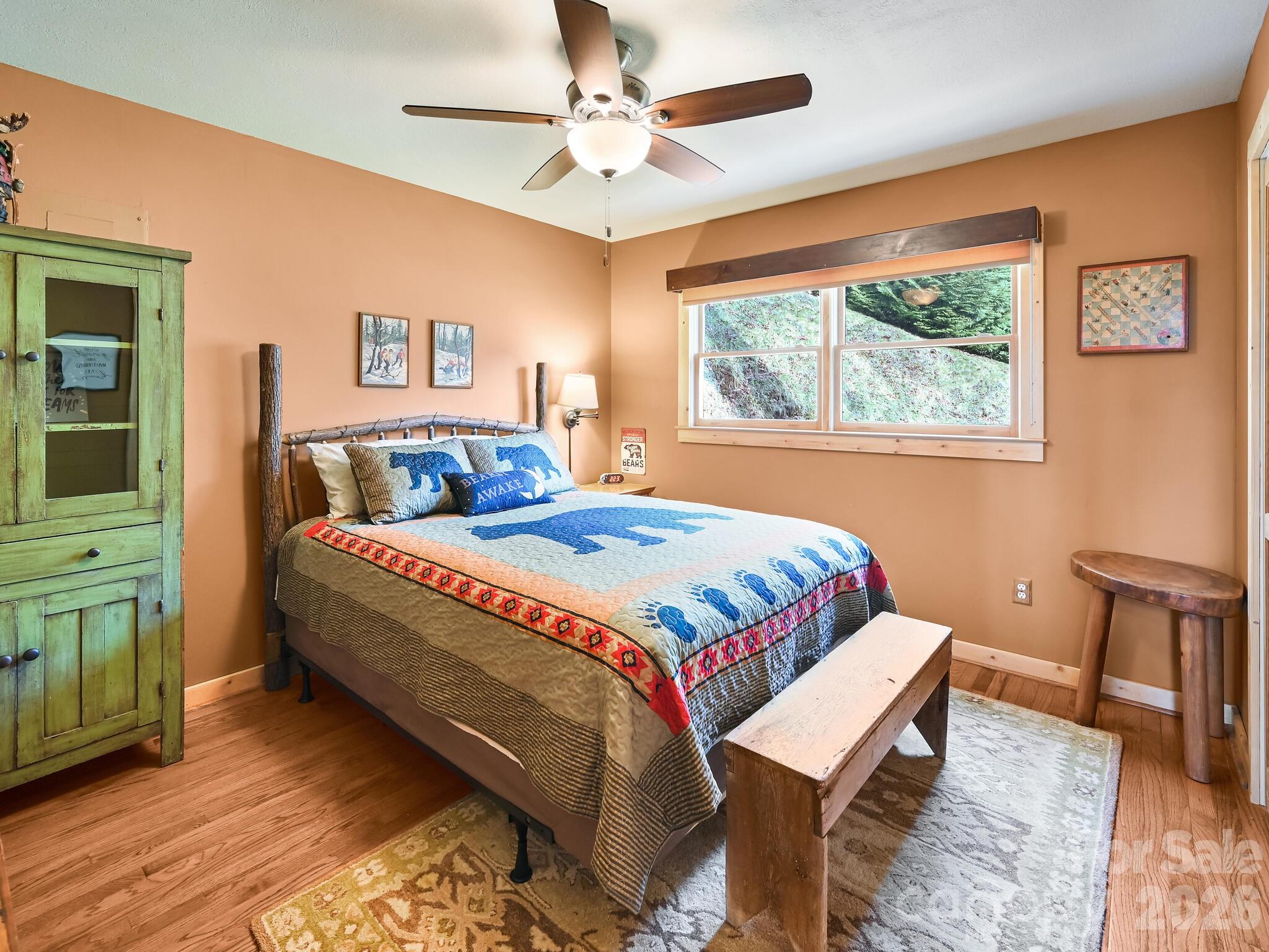 1954 Utah Mountain Road Waynesville, NC 28785 - Photo 20 of 36 a bedroom with a bed and a chandelier