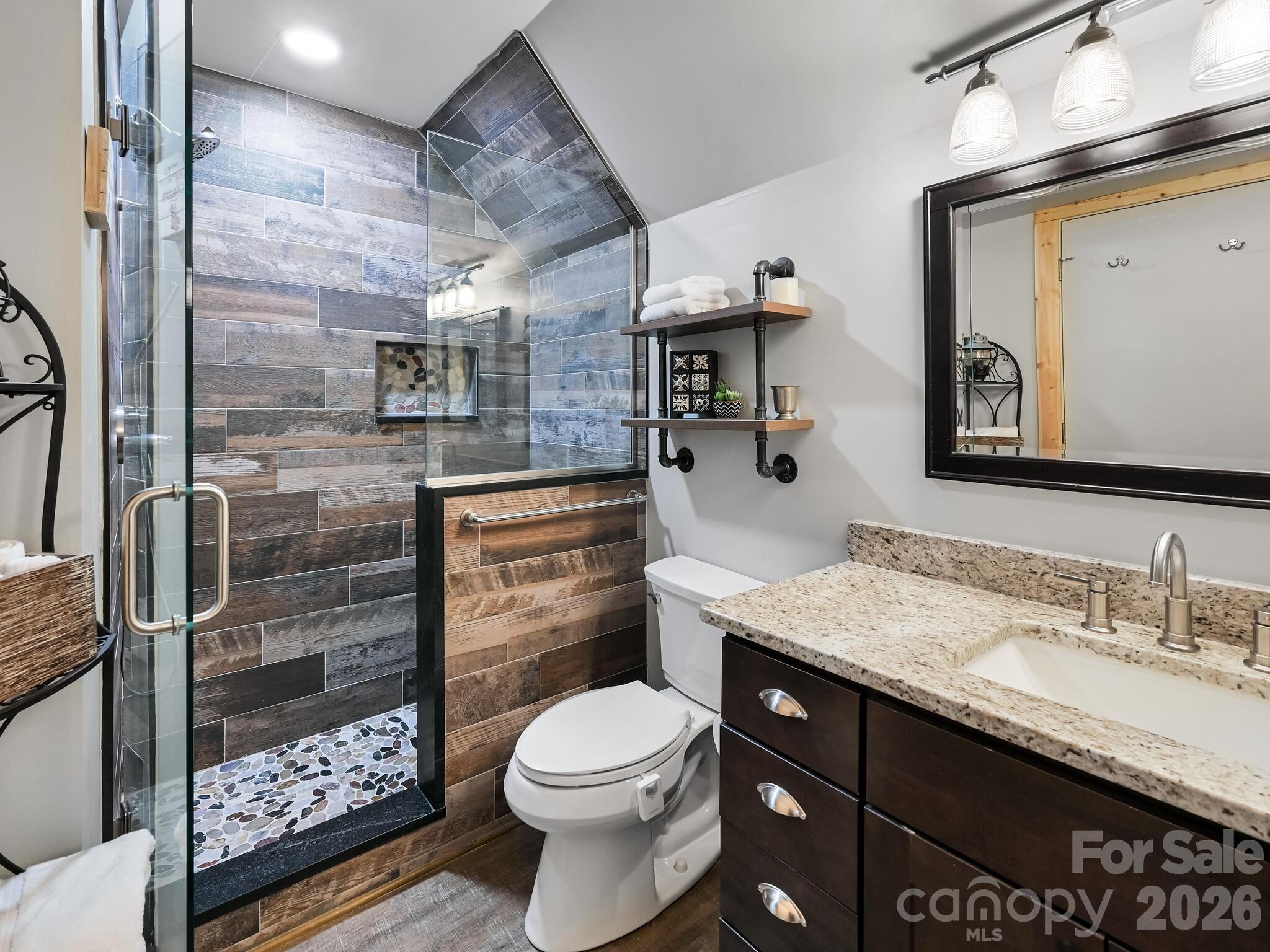 1954 Utah Mountain Road Waynesville, NC 28785 - Photo 28 of 36 a bathroom with a granite countertop toilet sink and mirror