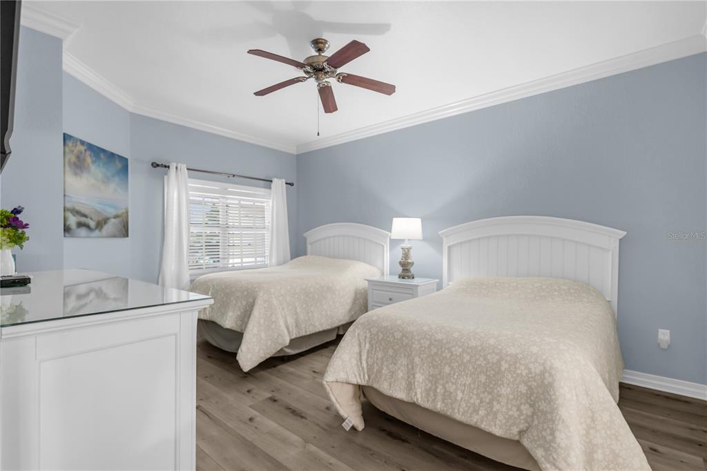 7618 Sandy Ridge Drive, Unit 103 Reunion, FL 34747 - Photo 14 of 37 a bedroom with two beds and a chandelier