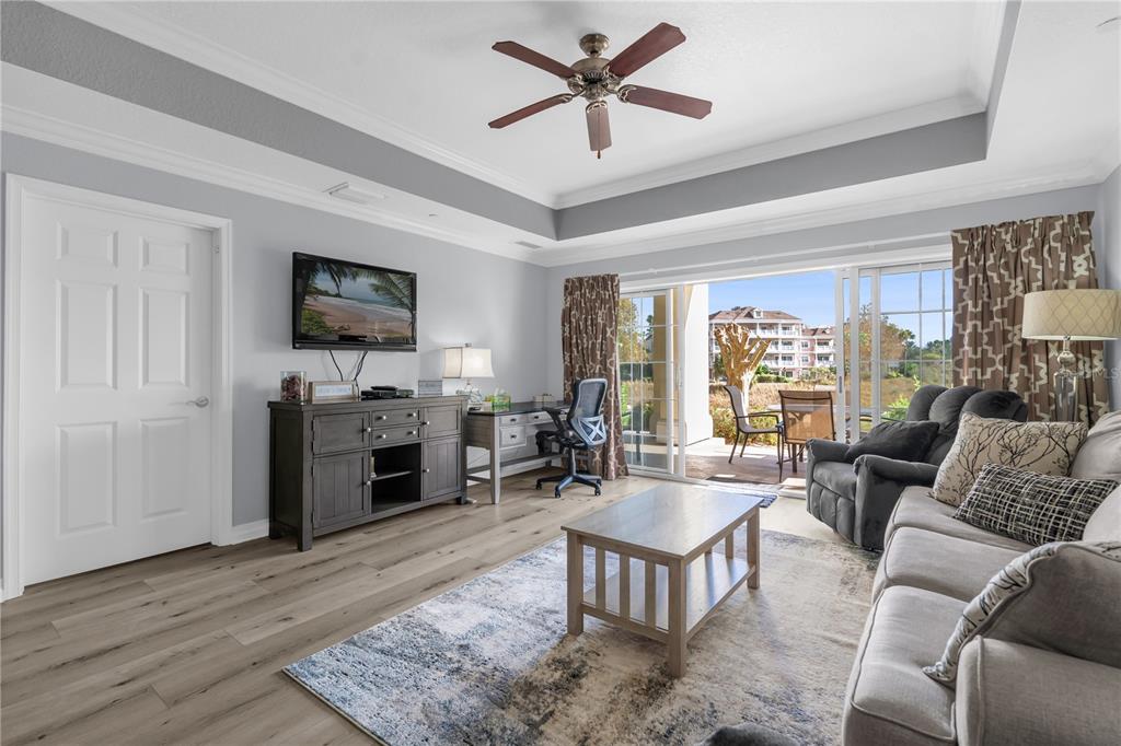 7618 Sandy Ridge Drive, Unit 103 Reunion, FL 34747 - Photo 5 of 37 a living room with furniture flat screen tv and a fireplace