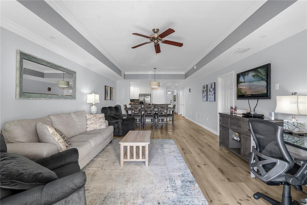 7618 Sandy Ridge Drive, Unit 103 Reunion, FL 34747 - Photo 6 of 37 a living room with furniture a flat screen tv and a window