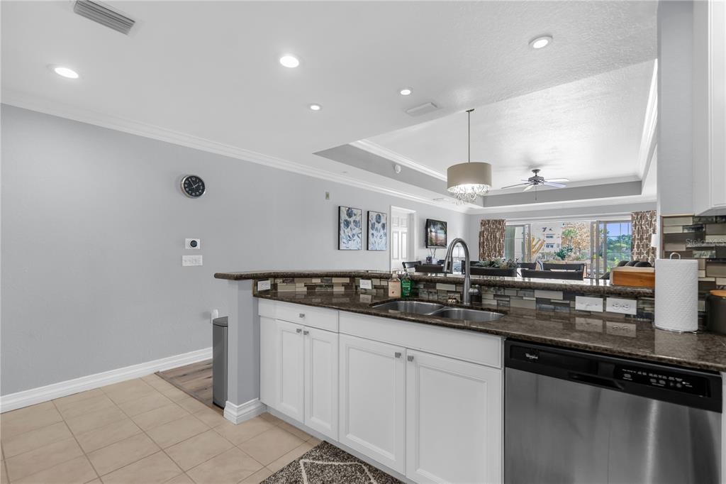 7618 Sandy Ridge Drive, Unit 103 Reunion, FL 34747 - Photo 8 of 37 a kitchen with granite countertop a sink and cabinets