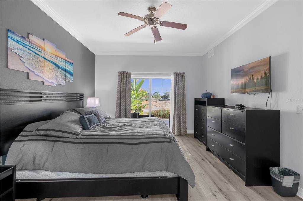 7618 Sandy Ridge Drive, Unit 103 Reunion, FL 34747 - Photo 10 of 37 a bedroom with furniture and flat screen tv