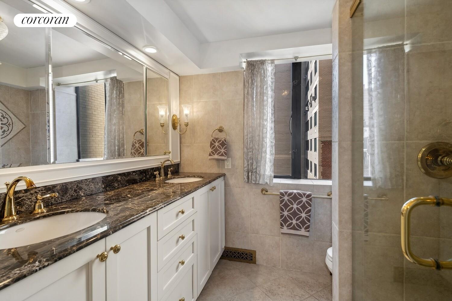 150 East 85th Street, Unit 8ABC Manhattan, NY 10028 - Photo 6 of 12 a bathroom with a granite countertop sink a mirror a vanity and a shower