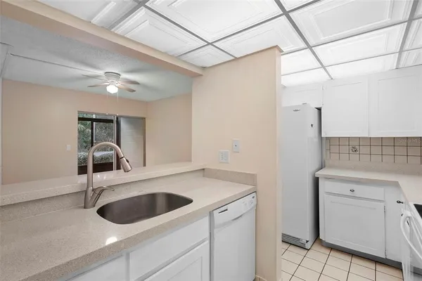 a kitchen with white cabinets and appliances