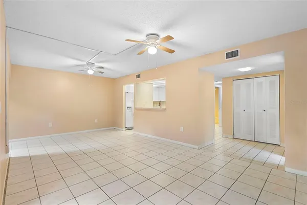 a view of an empty room and chandelier fan