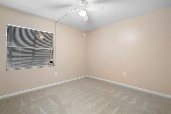 an empty room with chandelier fan