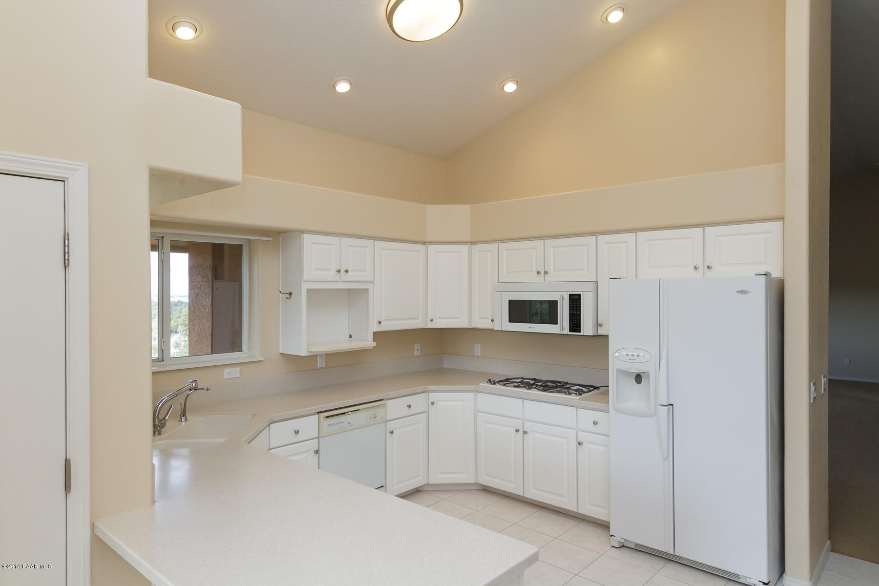1380 East Valley View Road Prescott, AZ 86303 - Photo 16 of 36 a kitchen with granite countertop white cabinets and white appliances