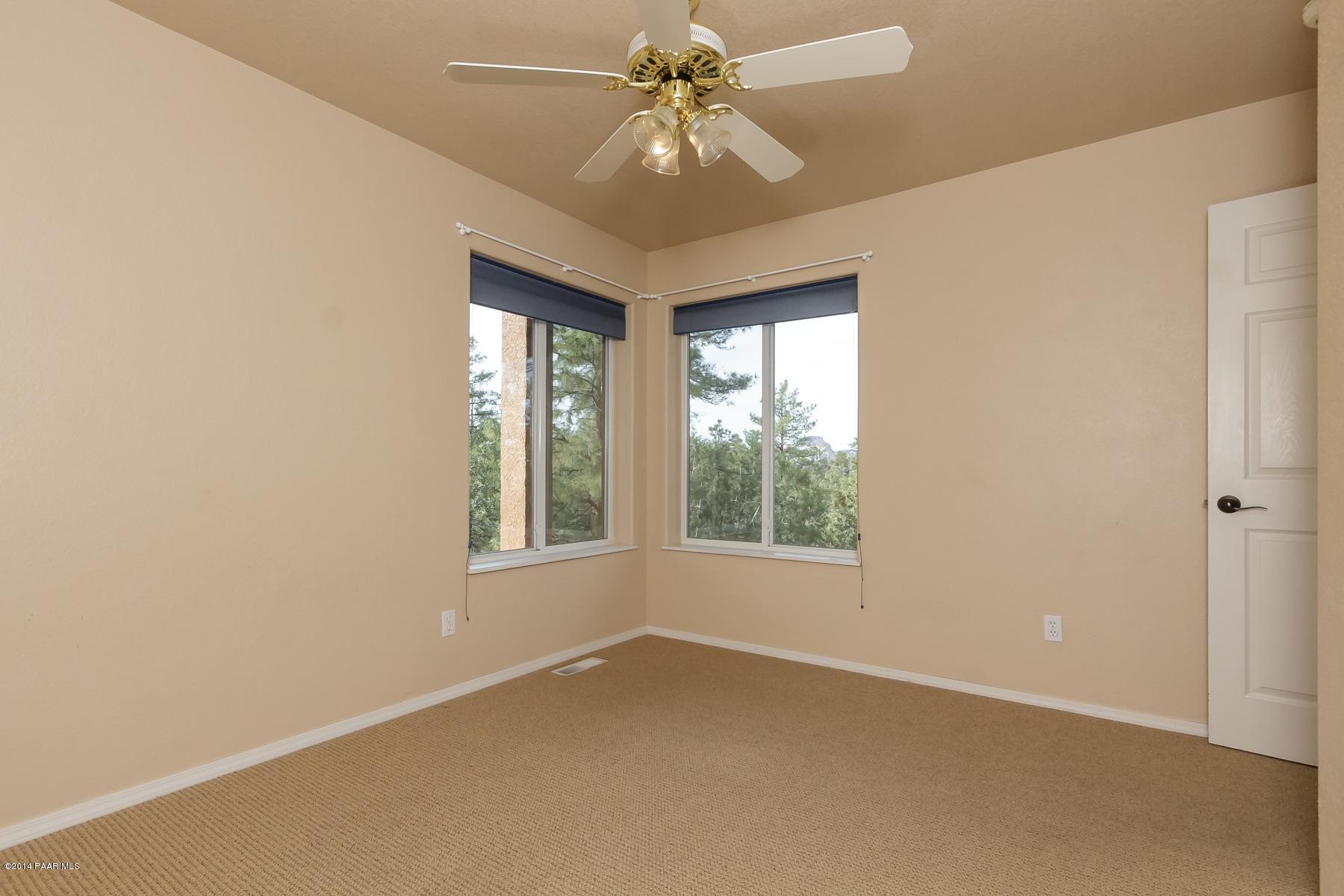 1380 East Valley View Road Prescott, AZ 86303 - Photo 30 of 36 an empty room with windows and chandelier fan