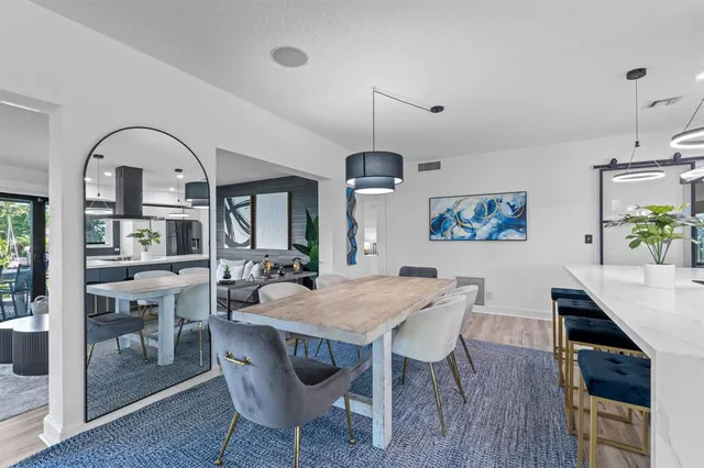 a kitchen with stainless steel appliances granite countertop a kitchen island a stove a table and chairs