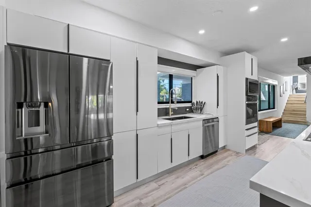 a living room with furniture floor to ceiling window and a potted plant