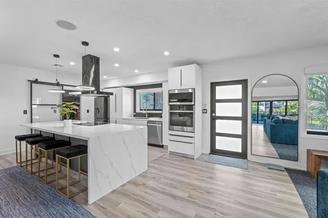 a kitchen with stainless steel appliances a refrigerator sink and cabinets