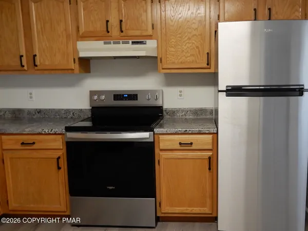 a kitchen with granite countertop cabinets stainless steel appliances and a counter space