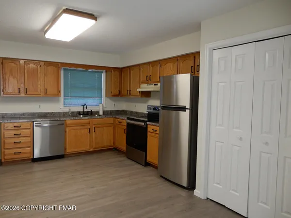 a kitchen with white cabinets stainless steel appliances and a window
