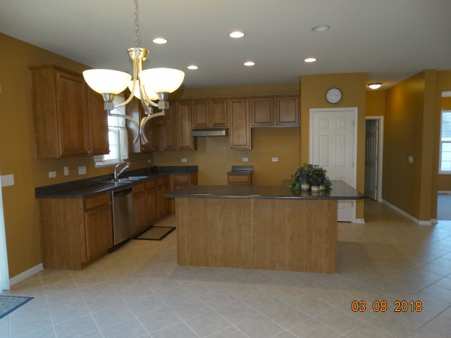 314 Monument Road Elgin, IL 60124 - Photo 3 of 16 a kitchen with stainless steel appliances granite countertop a refrigerator a sink dishwasher a oven and a dining table with wooden floor