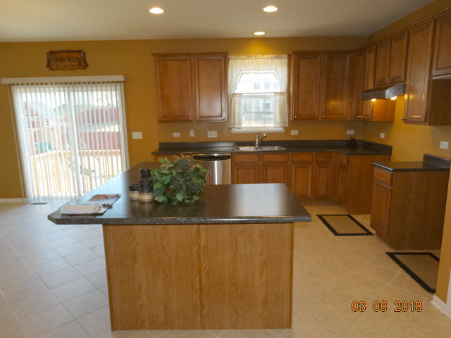 314 Monument Road Elgin, IL 60124 - Photo 4 of 16 a kitchen with granite countertop a sink a stove and a window