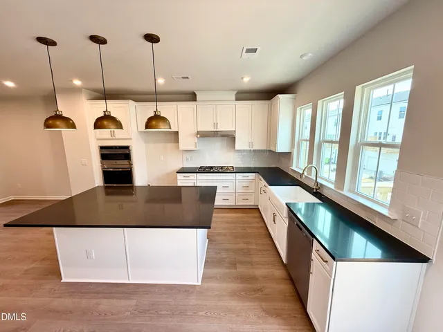 a kitchen with stainless steel appliances granite countertop a stove a sink and a refrigerator