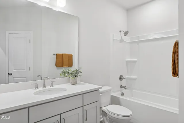 a bathroom with a granite countertop sink a toilet and shower