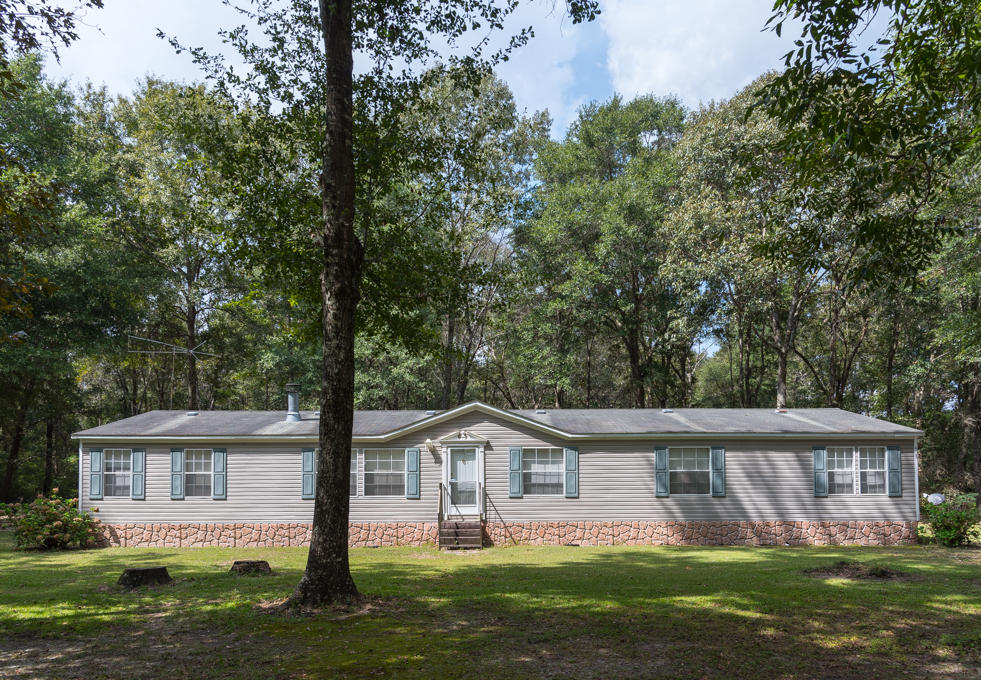 423 Tedder Road East DeFuniak Springs, FL 32433 - Photo 1 of 29 a front view of a house with a garden and trees