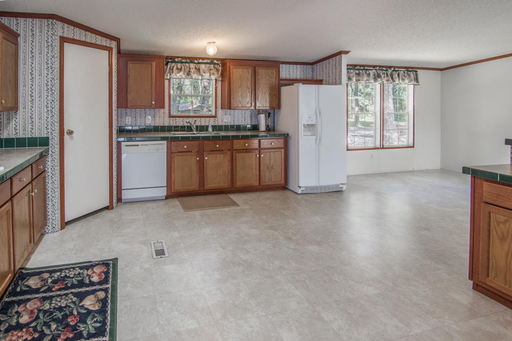 423 Tedder Road East DeFuniak Springs, FL 32433 - Photo 18 of 29 a kitchen with a refrigerator a stove top oven a sink and a window