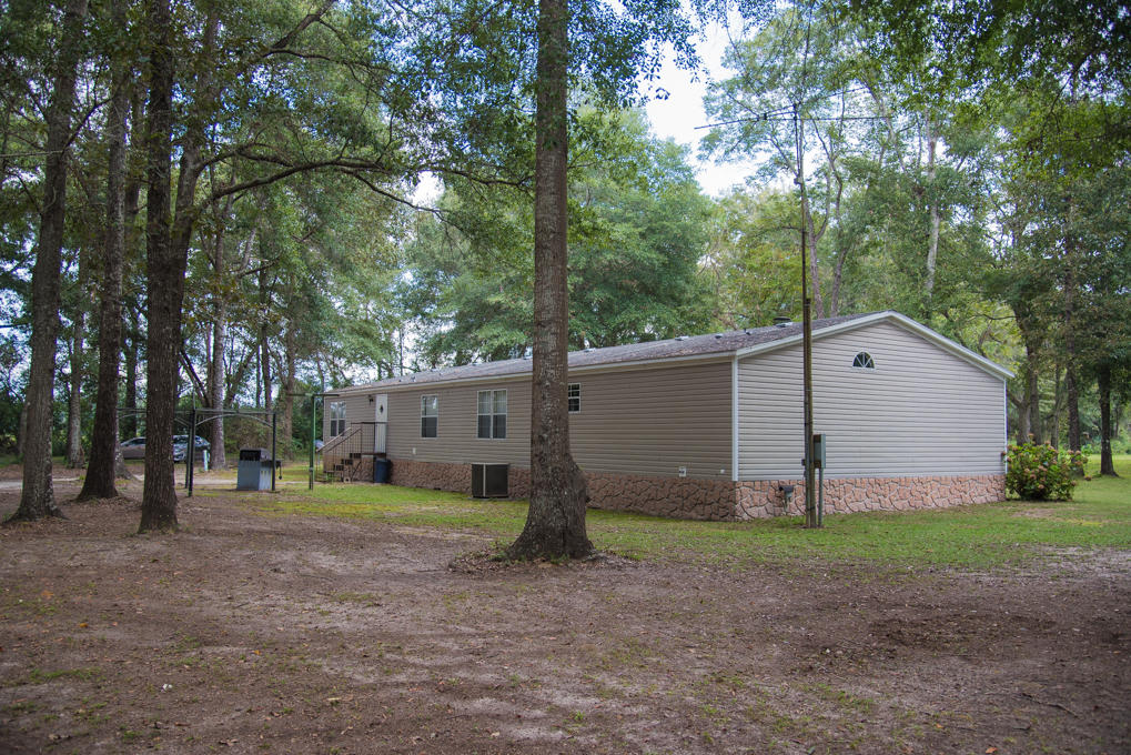 423 Tedder Road East DeFuniak Springs, FL 32433 - Photo 21 of 29 a view of a white house with a large tree and wooden fence